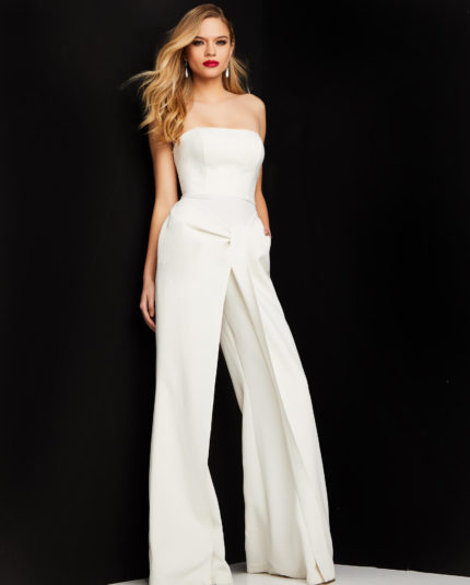 Model wearing Jovani 03828 ivory strapless jumpsuit front view with hands in pockets.