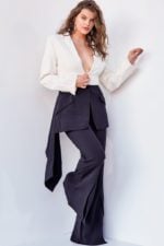 Model wearing Jovani 04148 black and ivory jumpsuit with blazer-style neckline, side front view.