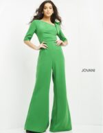 Model wearing Jovani 04284 emerald green jumpsuit with wide-leg pants and square neckline, front view.