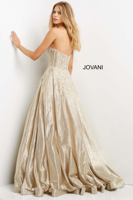 Back view of model in Jovani 07497 gold gown, showcasing elegant train and floral appliques.