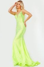 Model wearing Jovani 08157 neon green side view with detailed embellishments.