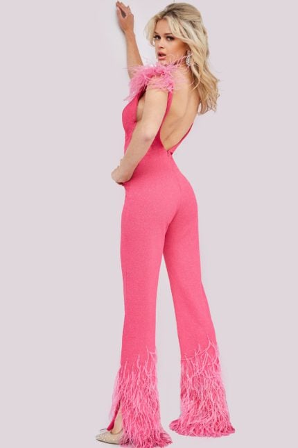 Back view of model wearing Jovani 08554 pink jumpsuit showing open back and feather trim.