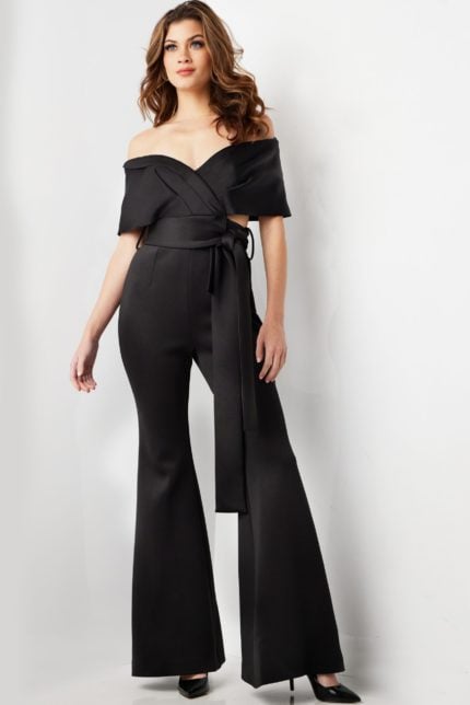 Model wearing Jovani 09726 black off-the-shoulder jumpsuit, front view