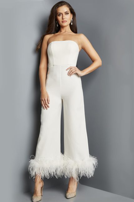 Model wearing Jovani 22590 ivory strapless jumpsuit with feathered hem from the front.