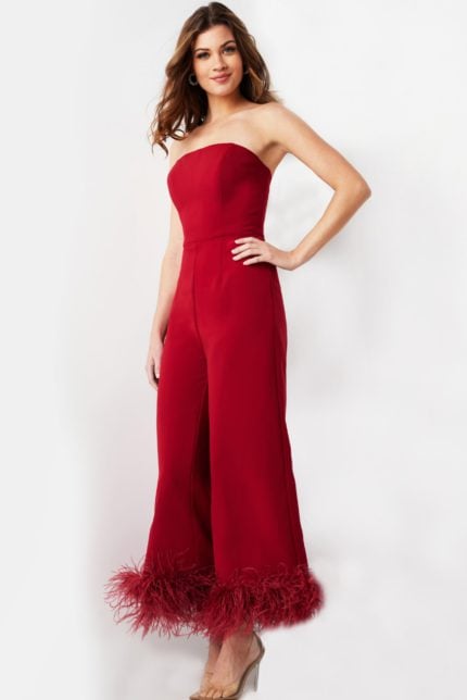 Model wearing Jovani 22590 elegant red strapless jumpsuit with feathered hems, front view.