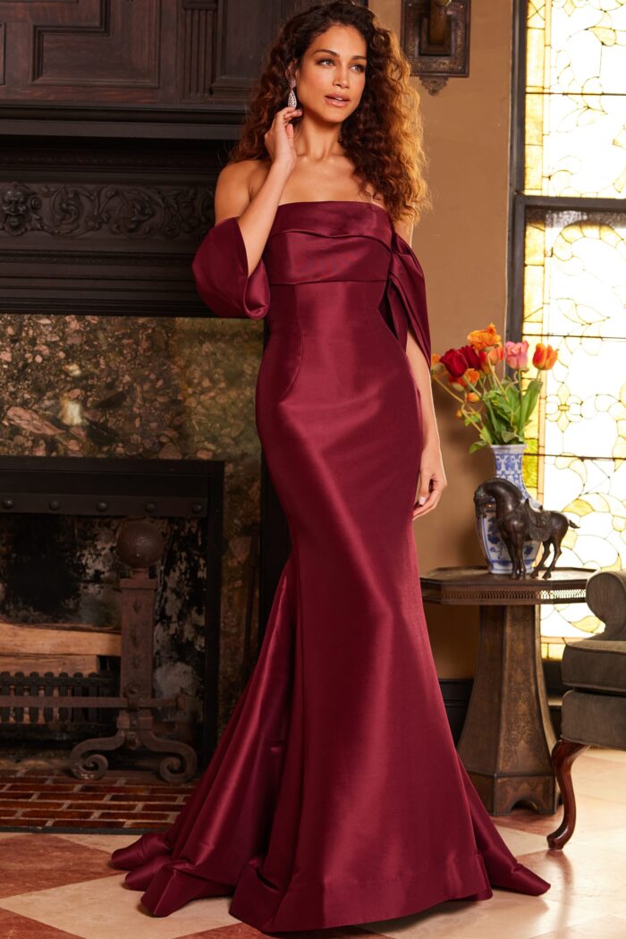 Model wearing Jovani 23398 Burgundy Off the Shoulder Mermaid Evening Dress