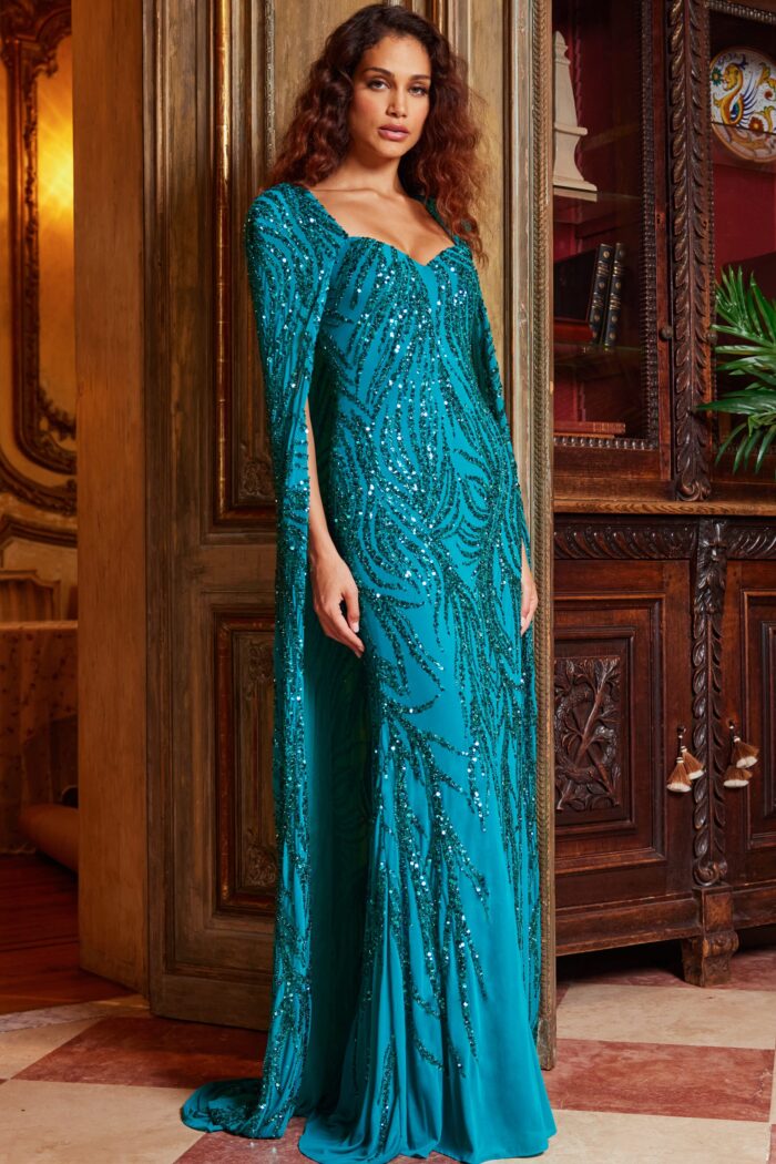 Model wearing Jovani 23891 Peacock Embellished Long Cape Evening Gown