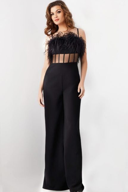 Model wearing Jovani 24144 black jumpsuit with sheer paneling and feather detail, front view.