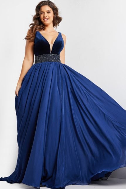 Model wearing 26201 navy gown with deep V-neckline and beaded waist, front view.