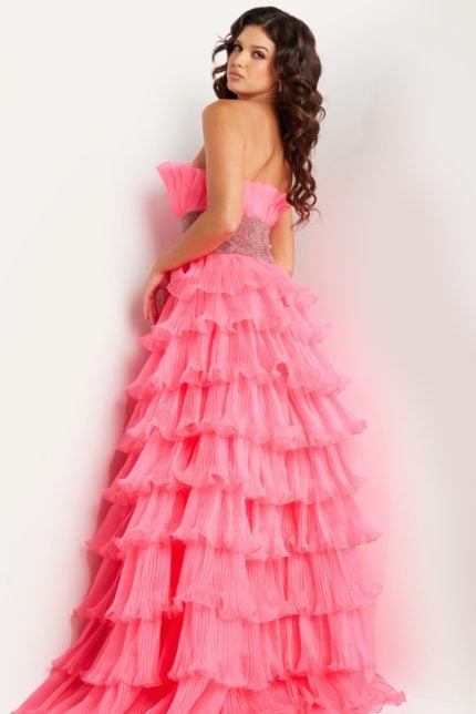 Model wearing Jovani 26314 pink gown with tiered ruffles, back view.