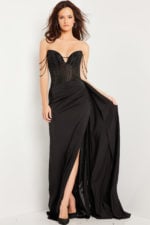 Model in a Jovani 36538 black gown with high slit and beaded bodice.