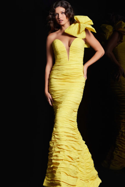 Model wearing Jovani 38240 yellow dress with deep V neckline and bow.