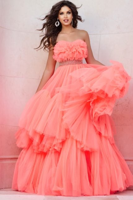 Model wearing Jovani 38299 orange gown with floral ruffles and embellished waist, back view.