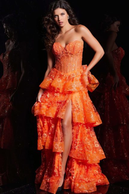 Model wearing Jovani 38528 orange gown with floral embroidery and tiered ruffles from the front