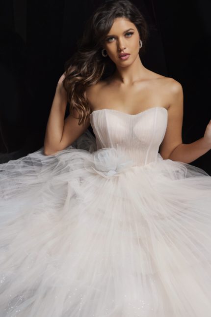 Model wearing Jovani 38537 blush ball gown with a strapless neckline and tulle skirt.