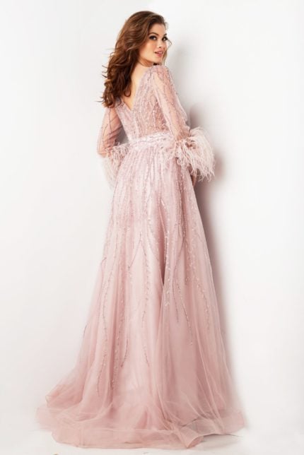 Model wearing Jovani 38583 blush gown showing the back with feathered cuffs and beaded details.