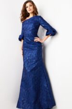 Model wearing Jovani 38791 navy mermaid gown with ruffled sleeves, front view, hand on hip.