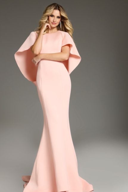 Model wearing Jovani 38822 blush dress showing bateau neckline and cape sleeves.