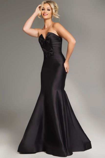 Model wearing Jovani 39872 black mermaid gown with bow detail front view