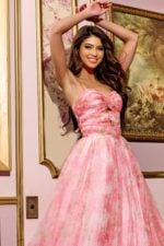 Model wearing Jovani 40402 pink floral A-line gown, side view.