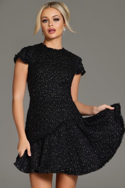 Model showcasing Jovani 40659 black dress with textured fabric and fringes.