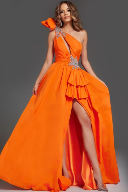 Model wearing Jovani 40929 orange one-shoulder gown with ruffle detailing and high slit