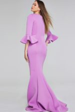 Model showing the back of Jovani 42579 lilac gown with mermaid silhouette and bell sleeves.