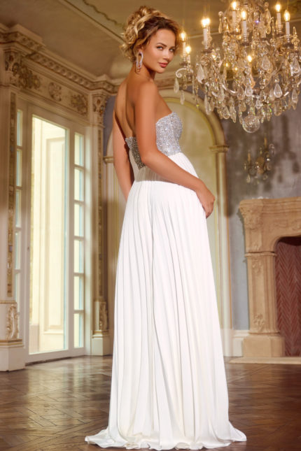 Back view of model wearing Jovani 42638 white gown showing pleated skirt.