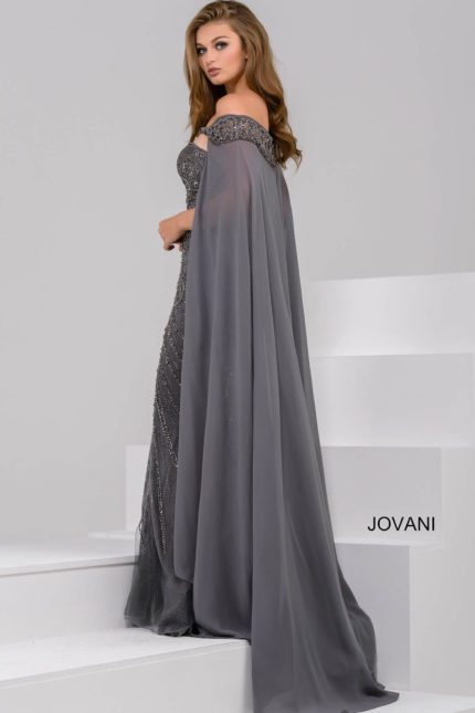 Model wearing Jovani 45566 gray gown with a view of the back and cape-like sleeves.