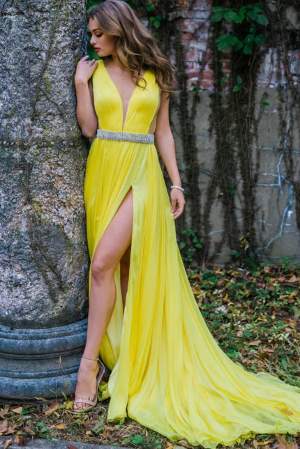 Model wearing Jovani S63599 beautiful yellow gown with V-neckline and high slit.