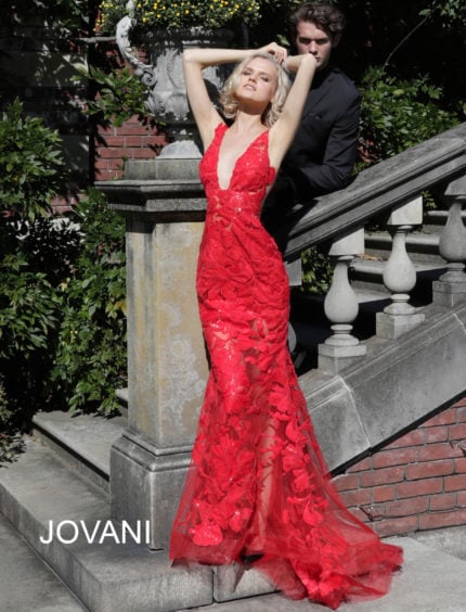 Model wearing Jovani 60283 red mermaid gown with plunging neckline and lace details.