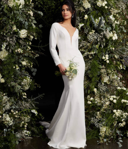 Model wearing Jovani JB06911 ivory gown featuring plunging neckline and long sleeves.