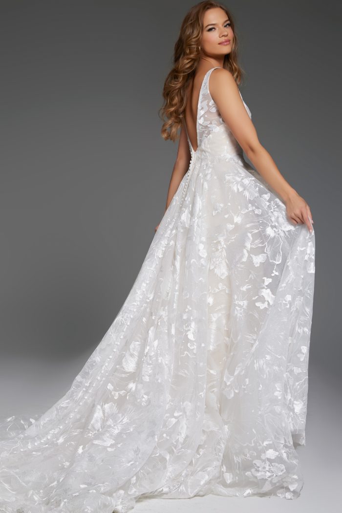 Elegant lace bridal gown with a flowing train by Jovani.