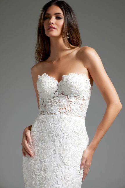 Close-up of model in Jovani JB39733 white gown with intricate lace detail and strapless design.