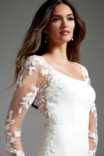 Model in Jovani JB42297 ivory gown, highlighting the sheer lace sleeves and elegant design.