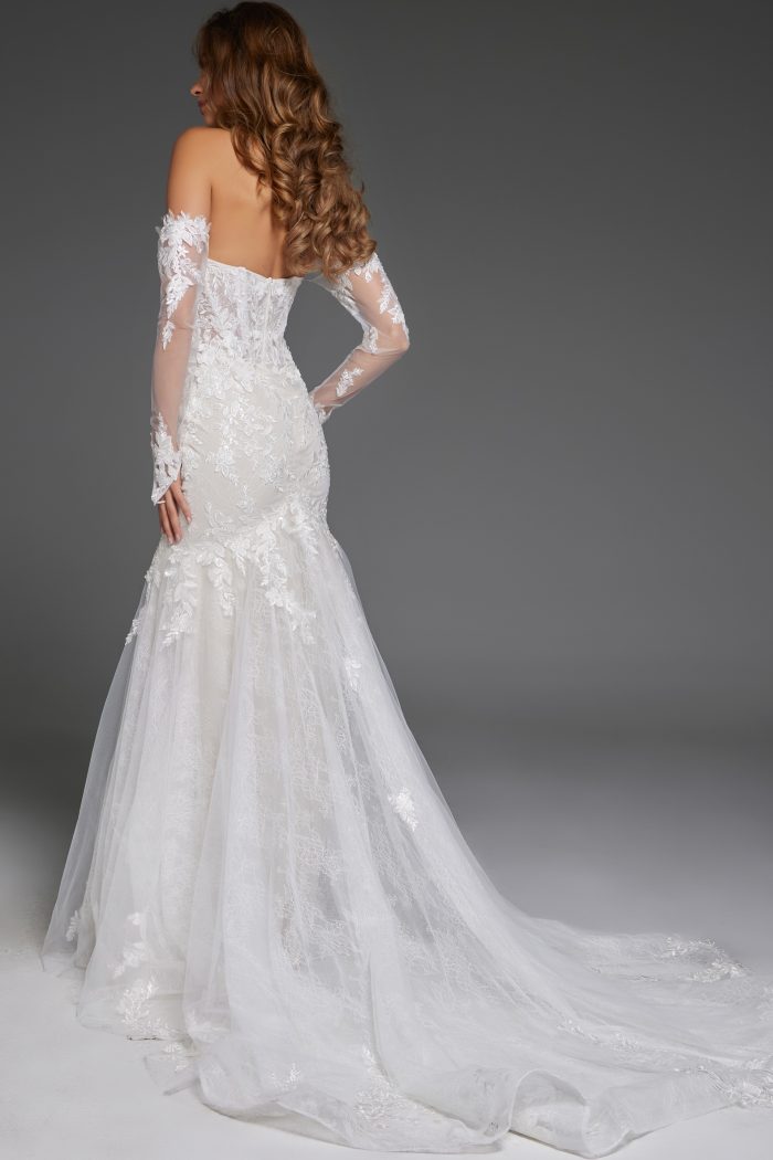 Back view of an off-shoulder lace wedding gown with long sleeves.