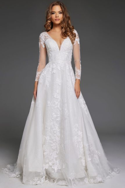 Model wearing Jovani JB43317 ivory gown with deep V-neckline and sheer long sleeves.