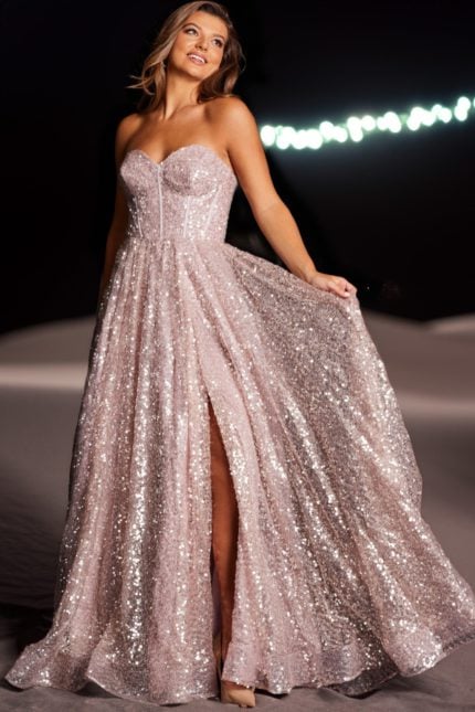 Model wearing Jovani 38607 blush gown showcasing a high slit.