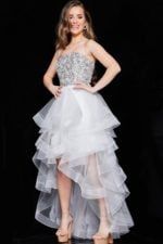 Model wearing Jovani K05916, a white dress with a sequin bodice and high-low tulle skirt, front view.