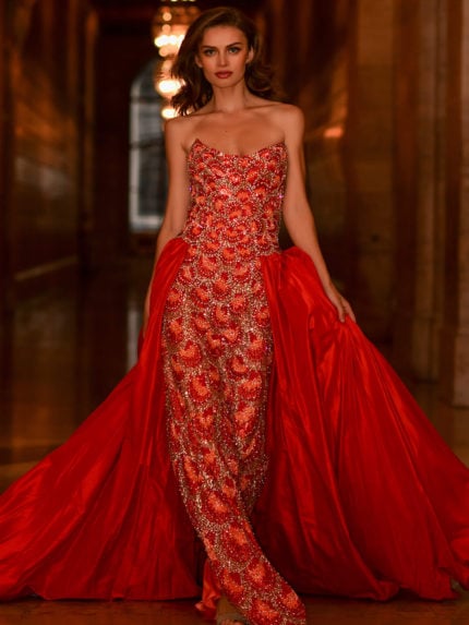 Model wearing S04603 vibrant orange gown with intricate beading and a strapless neckline.