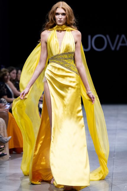 Model wearing S22826 yellow dress with V-neckline and high slit