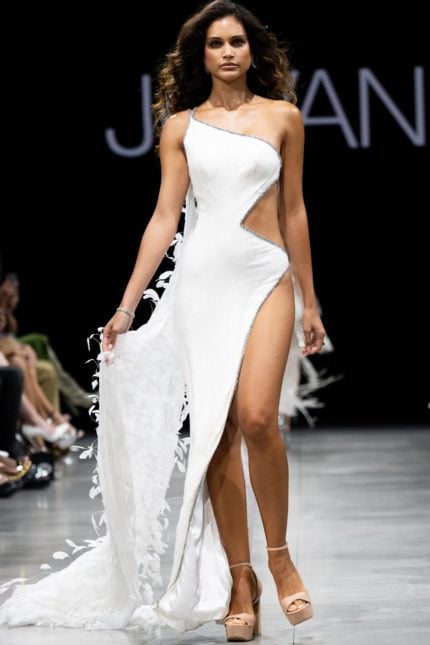 Model wearing Jovani S23231 white gown with high slit and one-shoulder neckline, front view.