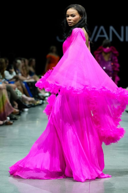 back view of model wearing S36352 vibrant pink gown with striking cape sleeves