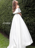 Model wearing Jovani S68287 white off-the-shoulder bridal gown side view.