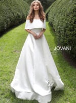 Model wearing Jovani S68287 white off-the-shoulder bridal gown with a romantic overlay.