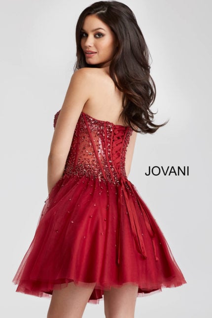 Model wearing Jovani 55142 burgundy short A-line dress with embellishments and lace-up back, rear view.